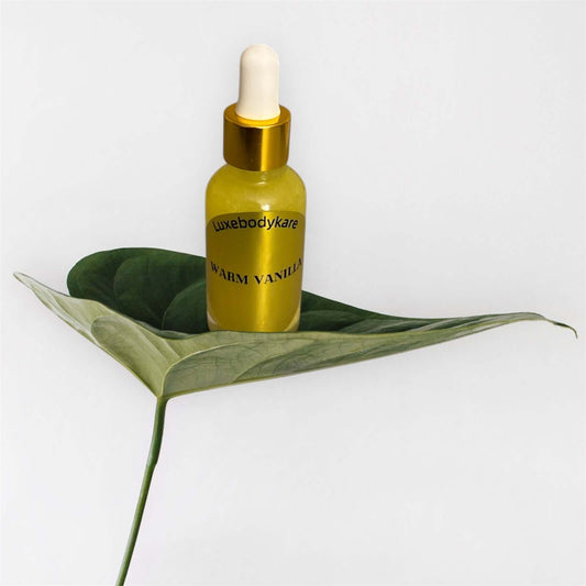 Luxebodykare body oil on a green leaf, showcasing luxurious hydration with Warm Vanilla scent.